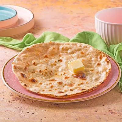 Traditional tandoor-cooked Indian bread, soft and golden, brushed with butter for a delicious finish.